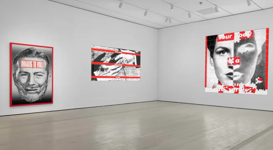 Large gallery space showcasing black, white, and red photographs of human figures. The photographs are overlaid with text,...