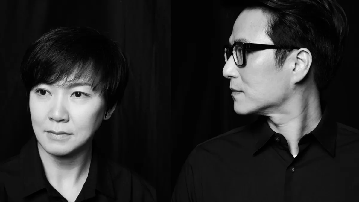 A black and white photograph features two individuals, Moon Kyungwon on the left and Jeon Joonho on the right, both looking at the camera.