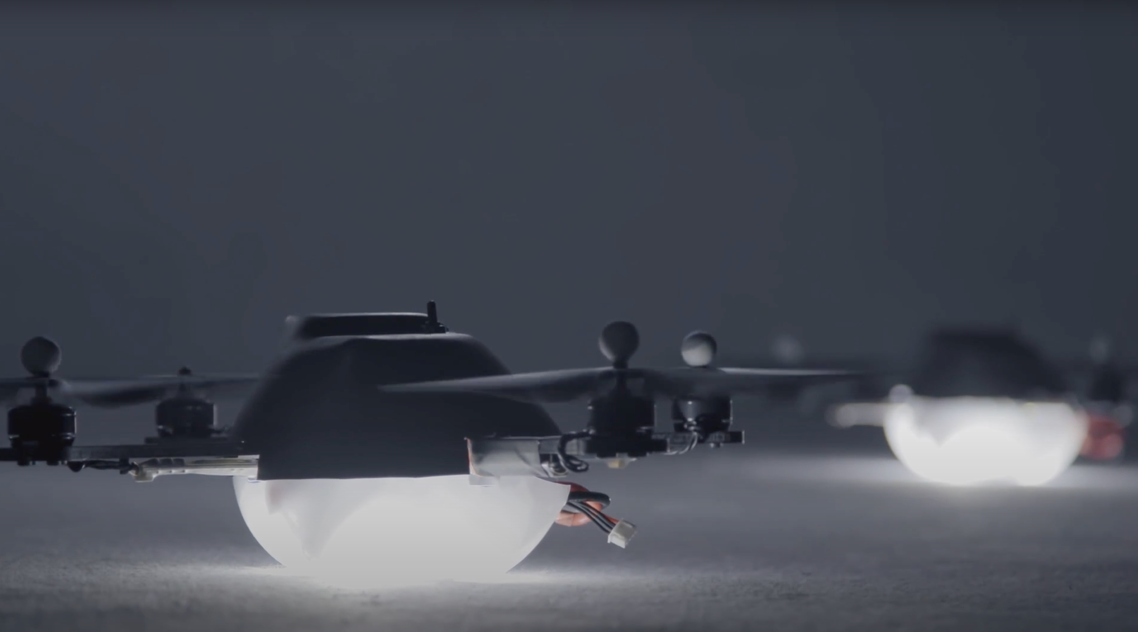 White light bulbs attached to drones are arranged on a grey ground, ready to take flight in a visual spectacle.