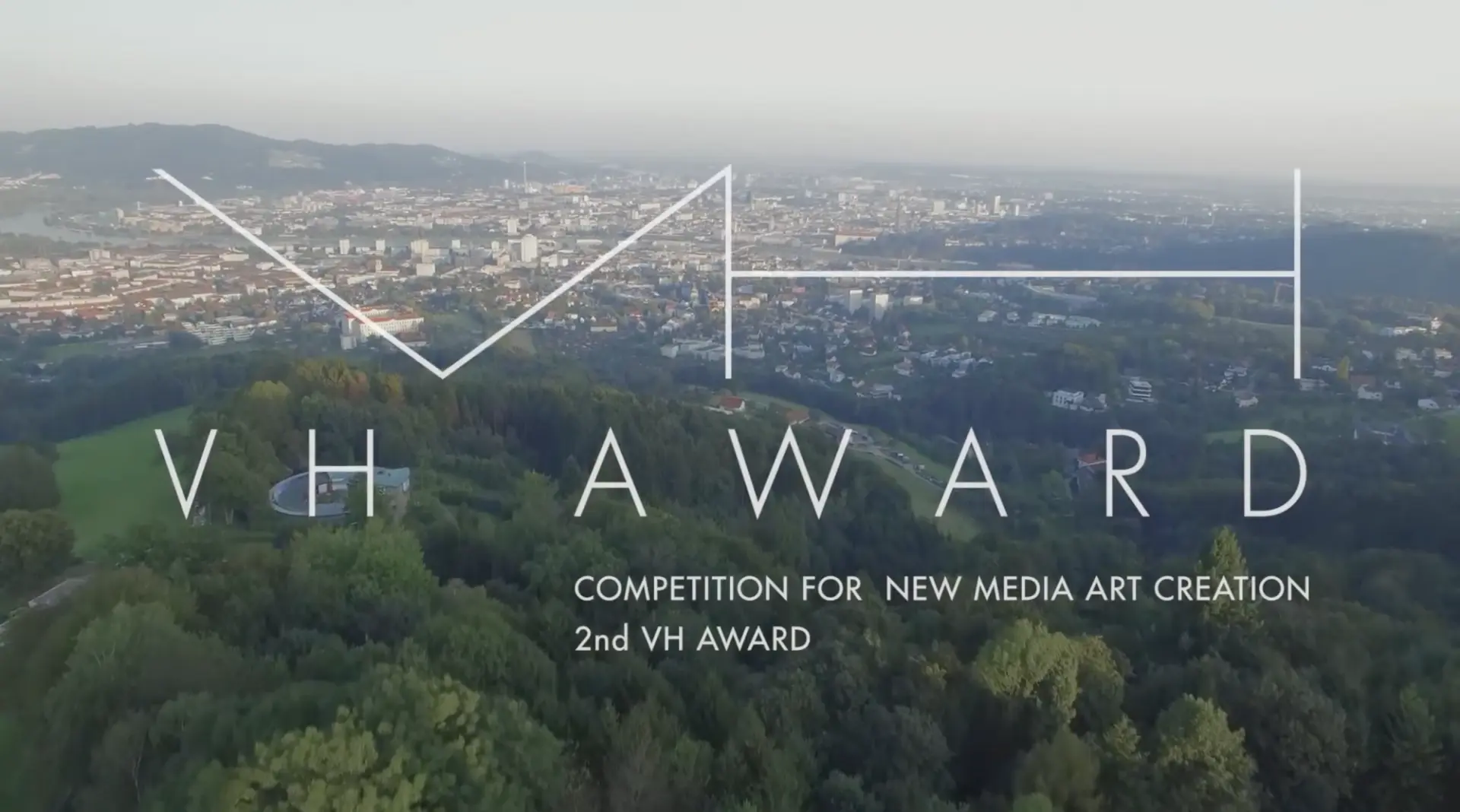 A sweeping cityscape extends below a hill, with a caption reading "Competition for New Media Art Creation 2nd VH AWARD" ov...