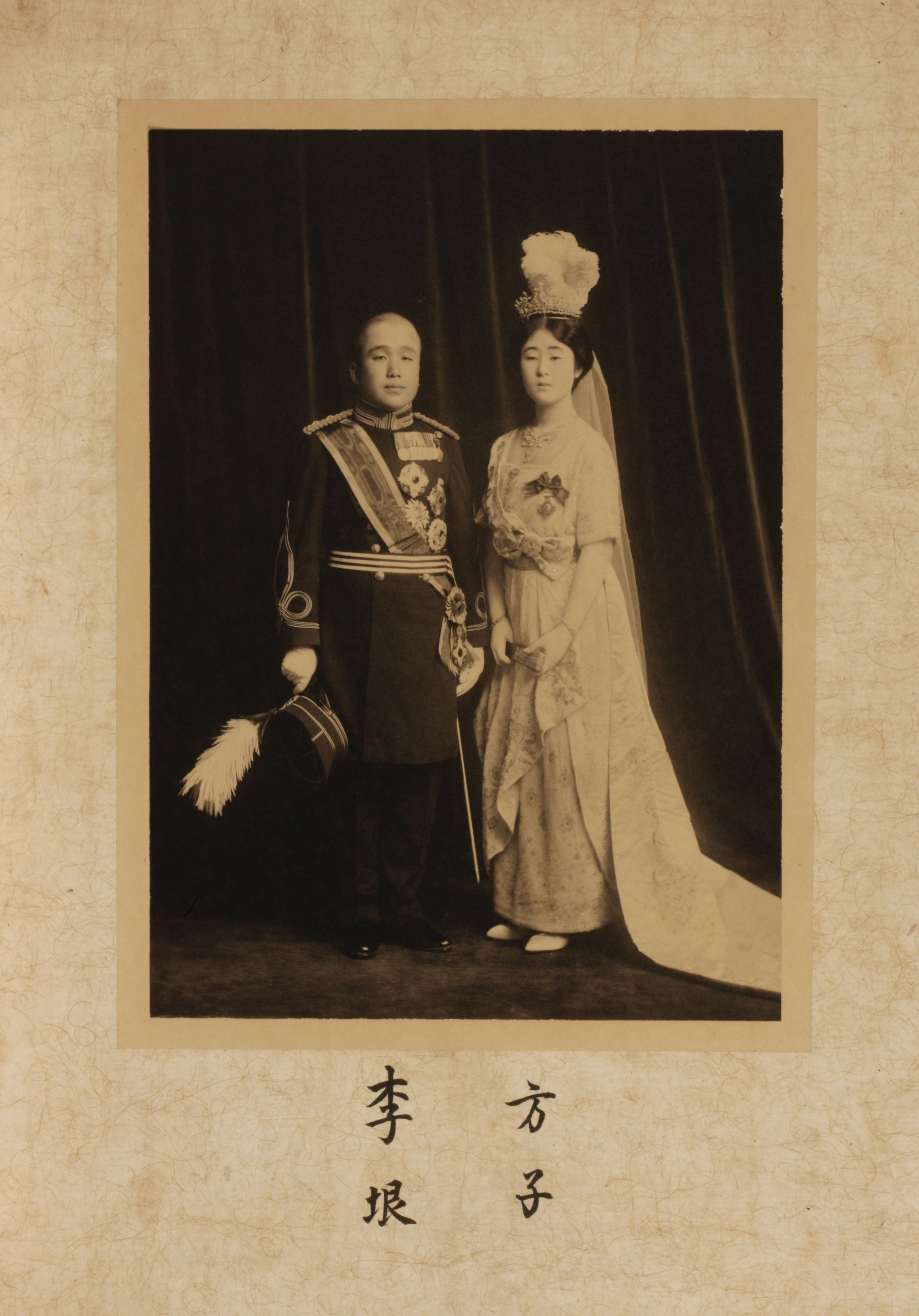 Vintage sepia-toned photograph capturing the wedding of two individuals, one in military uniform and the other in a white ...