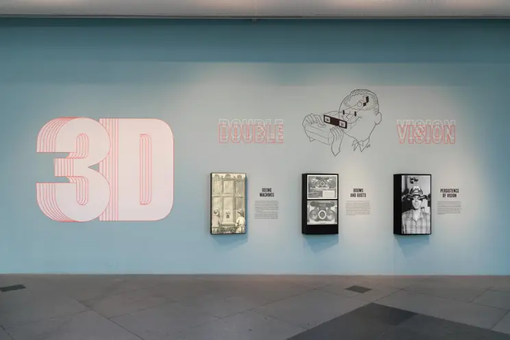 An exhibition titled "3D: Double Vision" displayed on a light blue wall at the Los Angeles County Museum of Art.