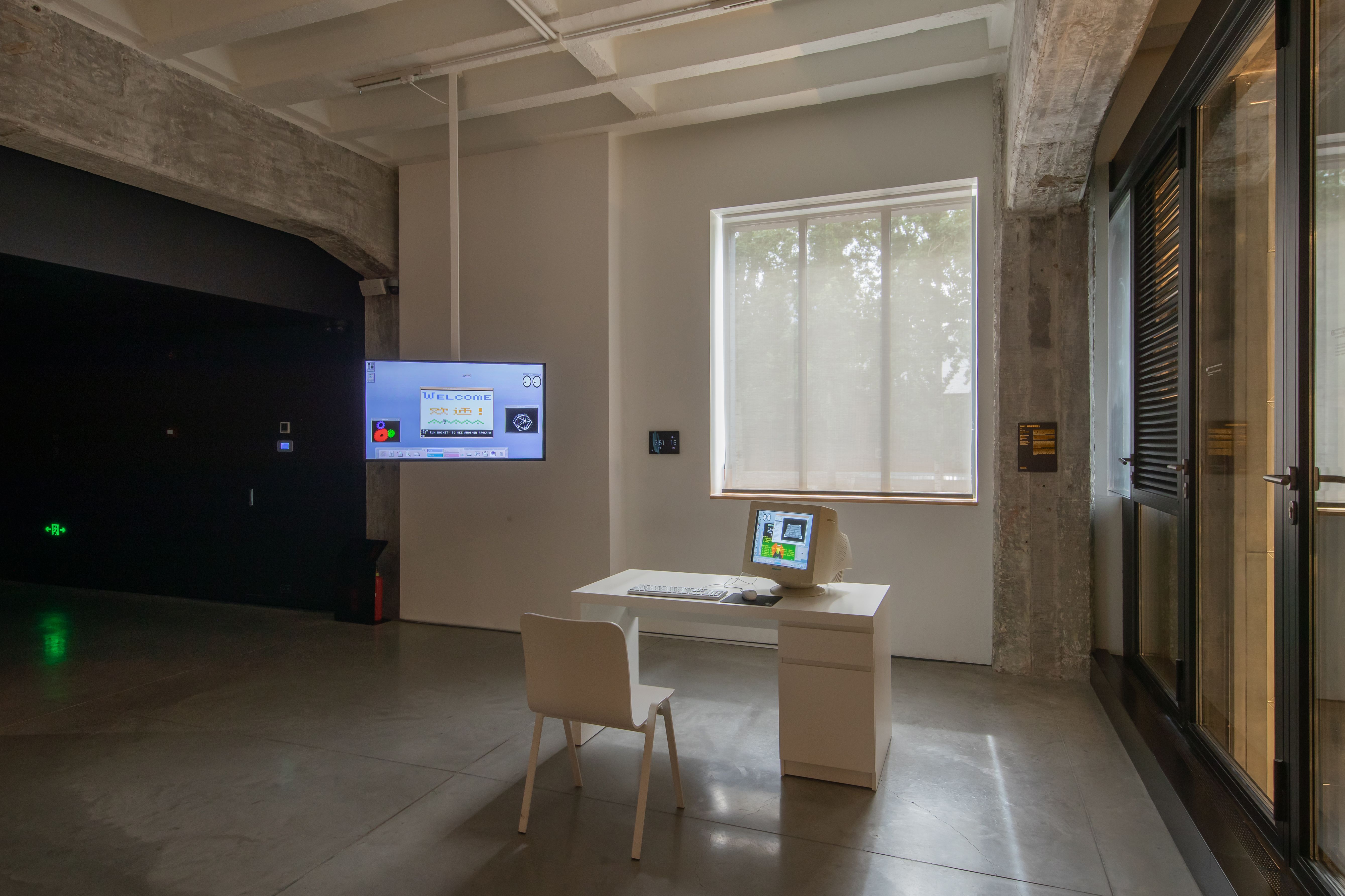 Modern office with computer desk and interactive welcome screen.