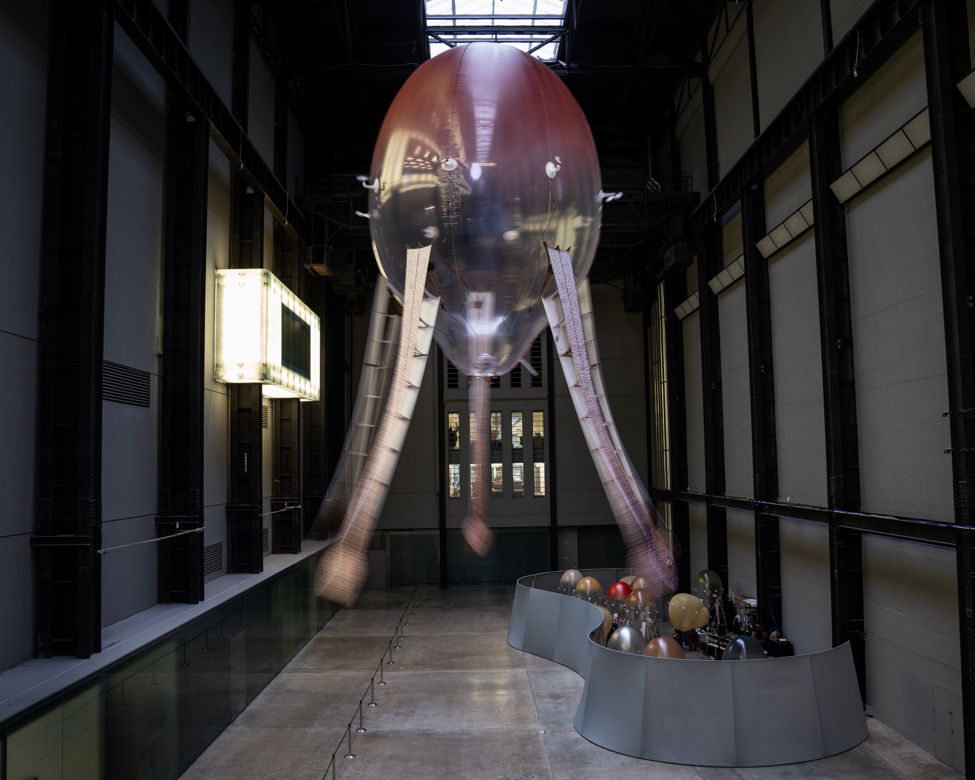 An industrial-styled installation features an octopus-shaped ceiling lamp with snake-headed tentacles, in an expansive gal...