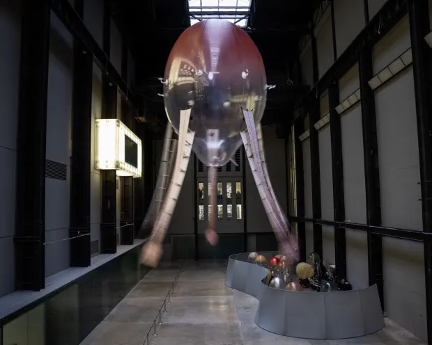 An industrial-styled installation features an octopus-shaped ceiling lamp with snake-headed tentacles, in an expansive gal...