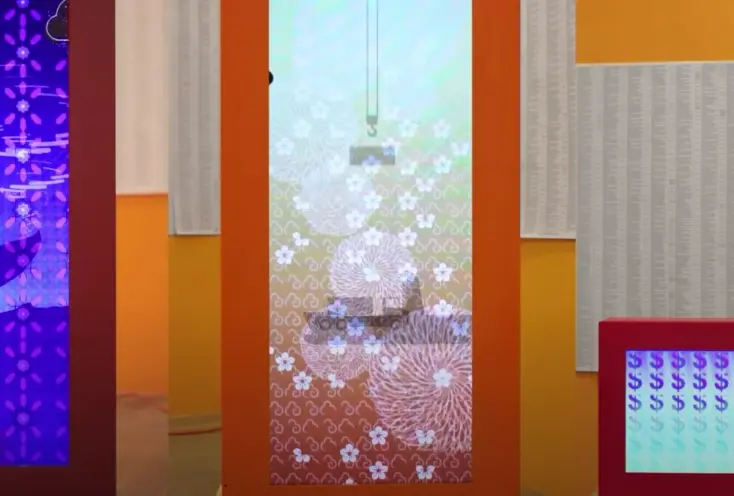 A vibrant collage featuring a variety of motifs adorns orange, yellow, and red walls. Materials with floral patterns, docu...