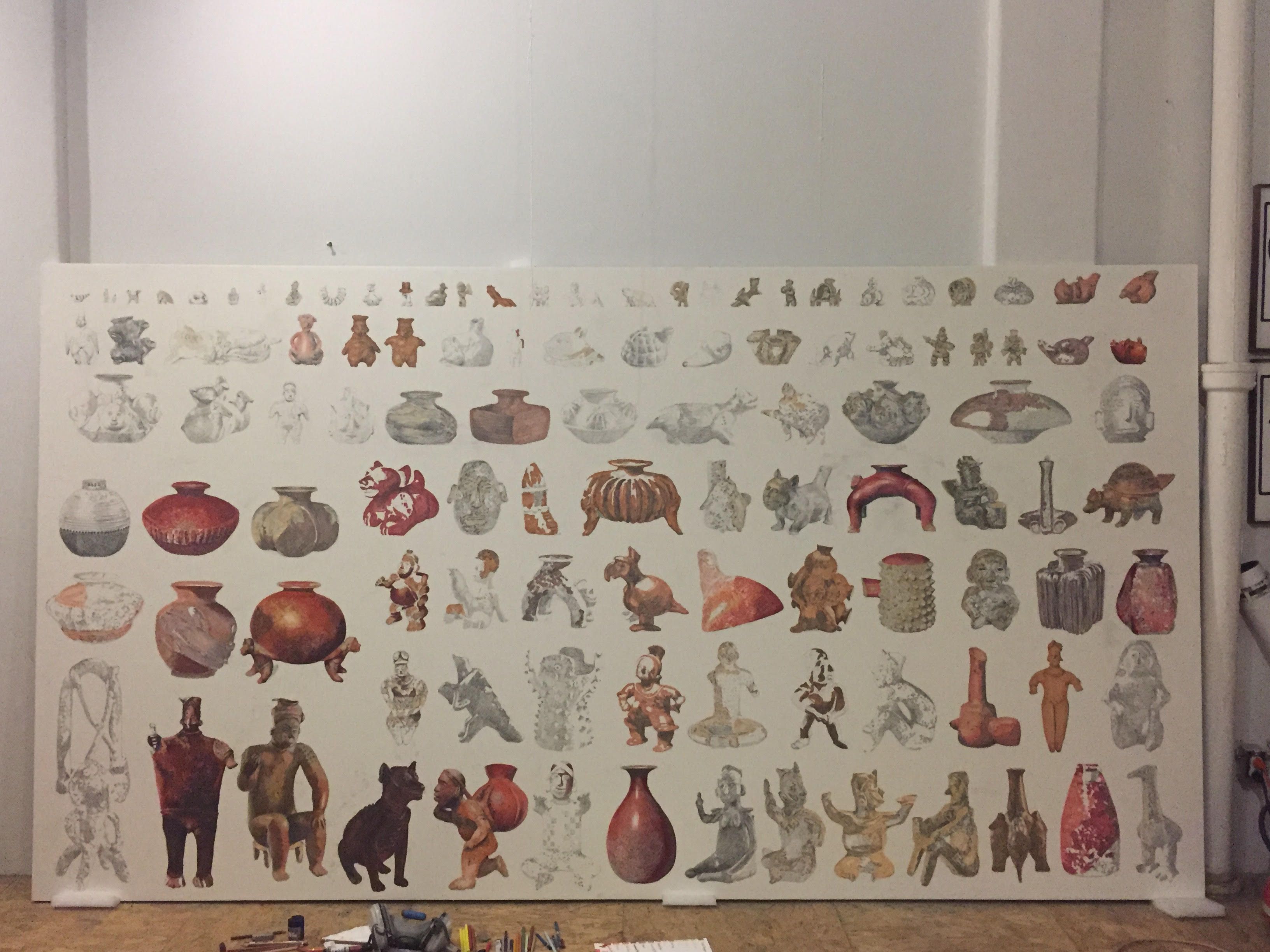 An in-progress mural featuring detailed sketches and colorful elements of ancient pottery and figurines.