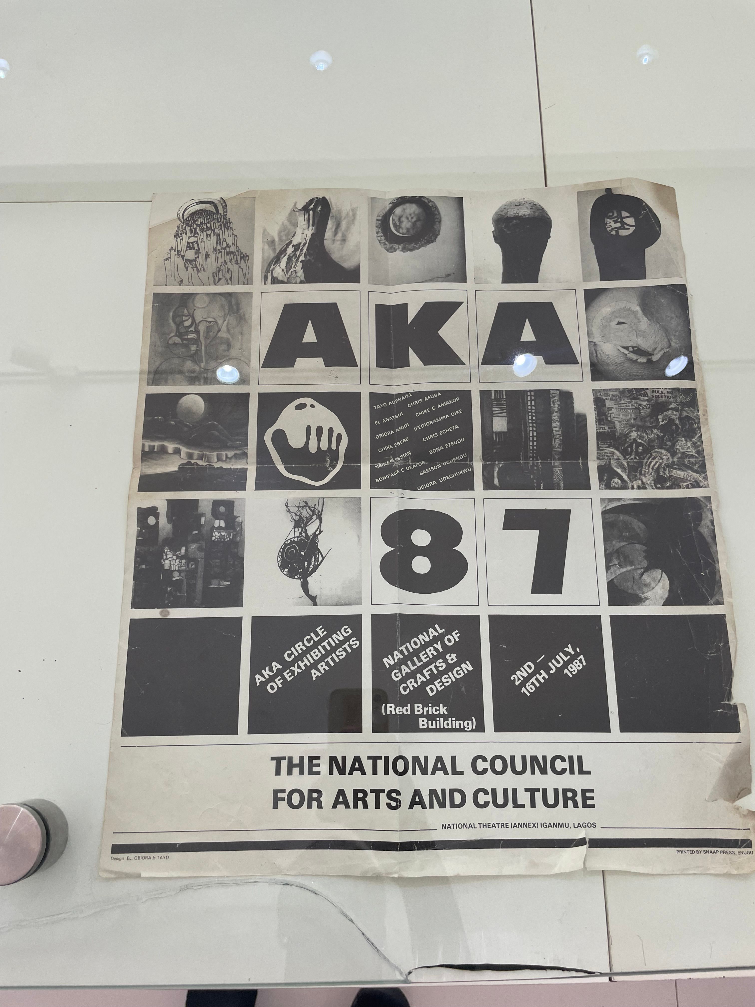 A vintage exhibition poster for "AKA 87" featuring artwork thumbnails and event details.