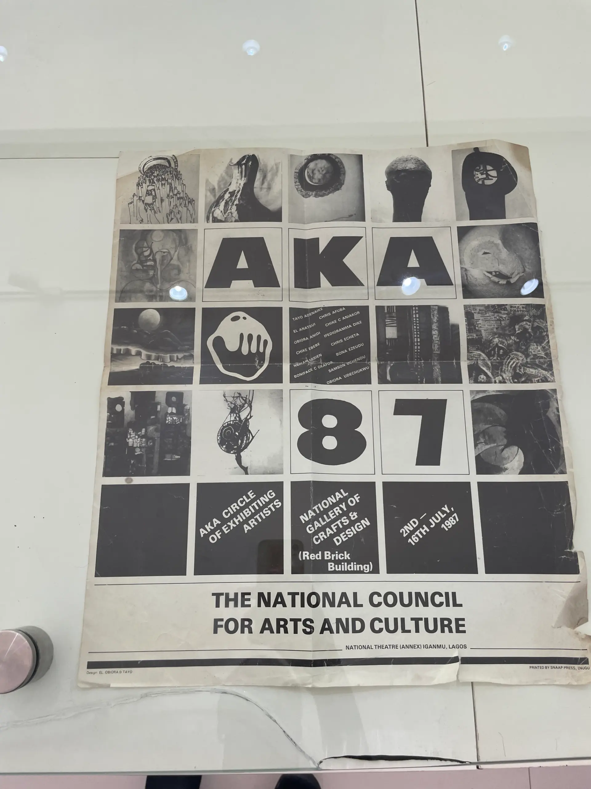 A vintage exhibition poster for "AKA 87" featuring artwork thumbnails and event details.