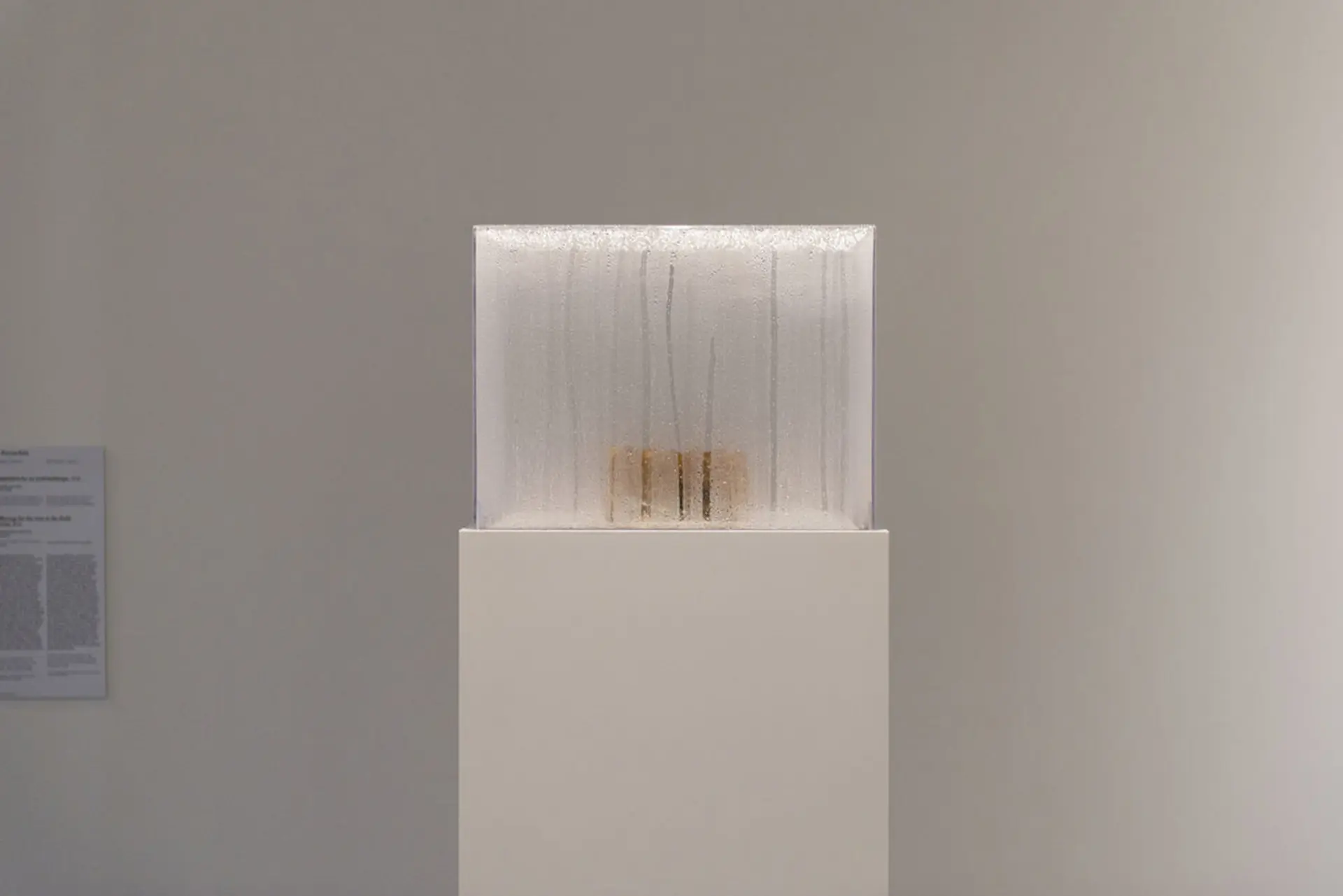 A framed piece featuring a handprint on a delicate white cloth set inside a wooden box.