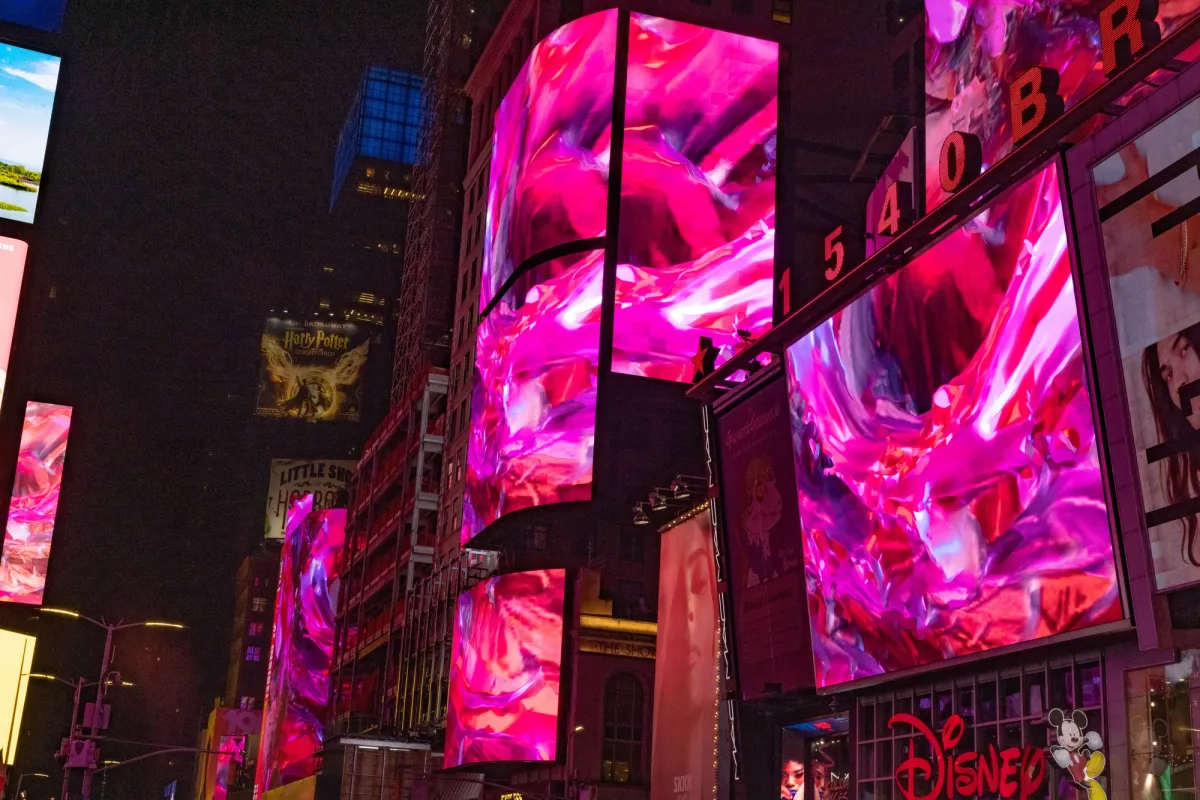 Abstract art depicted on massive building billboards, featuring swirls of pink tones, as part of Nancy Baker Cahill's 2022 Slipstream installation in Times Square.
