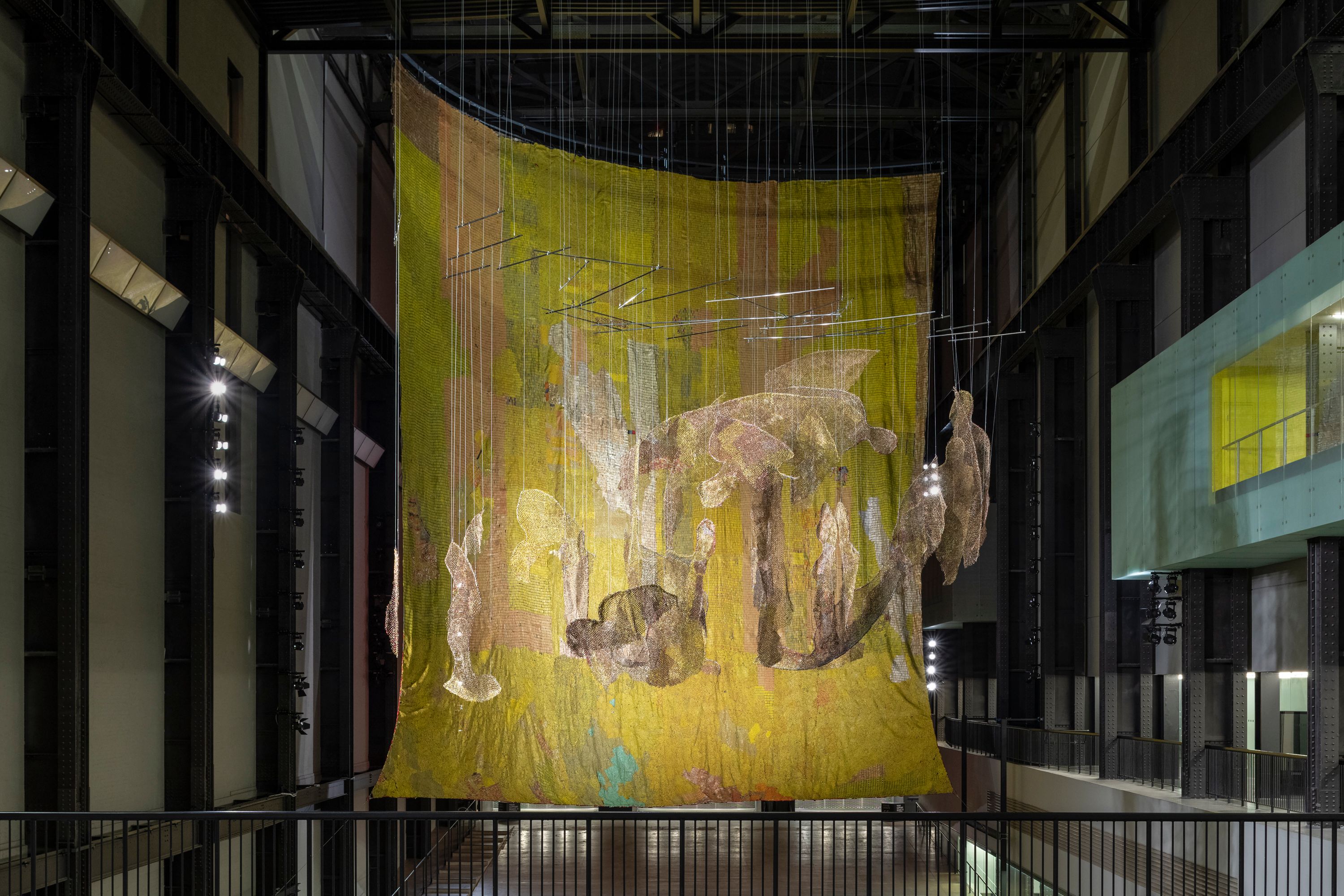 Large yellow fabric installation hanging in a gallery space.