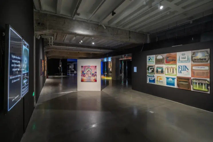Long gallery shot with a digital informational display and vibrant wall art.