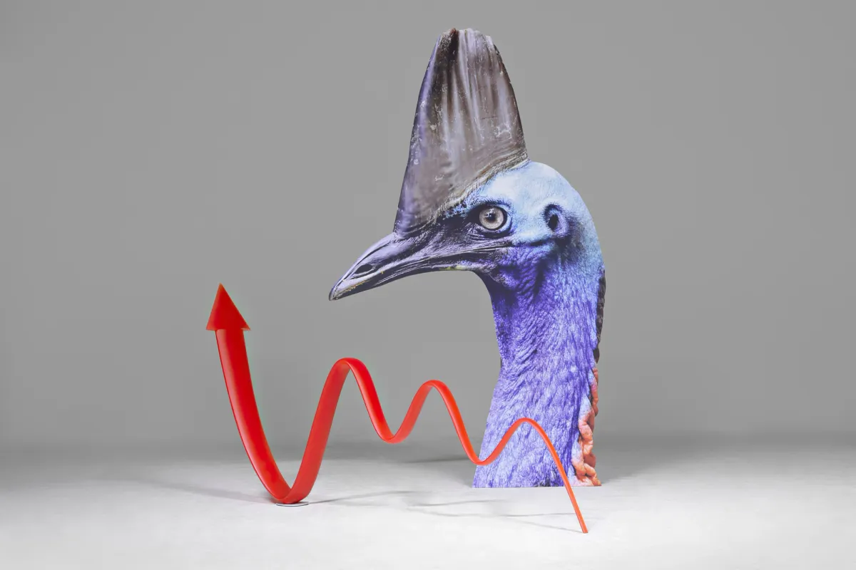 A digital print of a bird with detailed feathers on aluminum, next to a polyurethane and steel sculpture of a red upward arrow on a vibrant electric blue background.