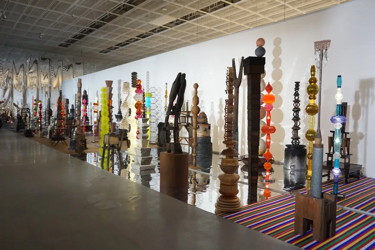 An array of assorted sculpture objects in various shapes and sizes positioned strategically across a well-lit gallery space.
