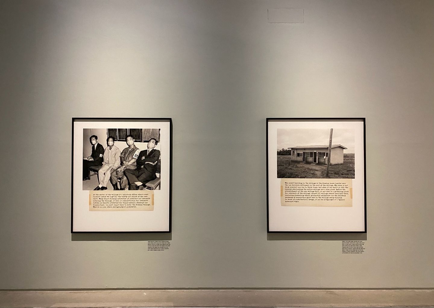 Two vintage photographs displayed in a gallery. One frame captures four individuals, while the other depicts a quaint buil...