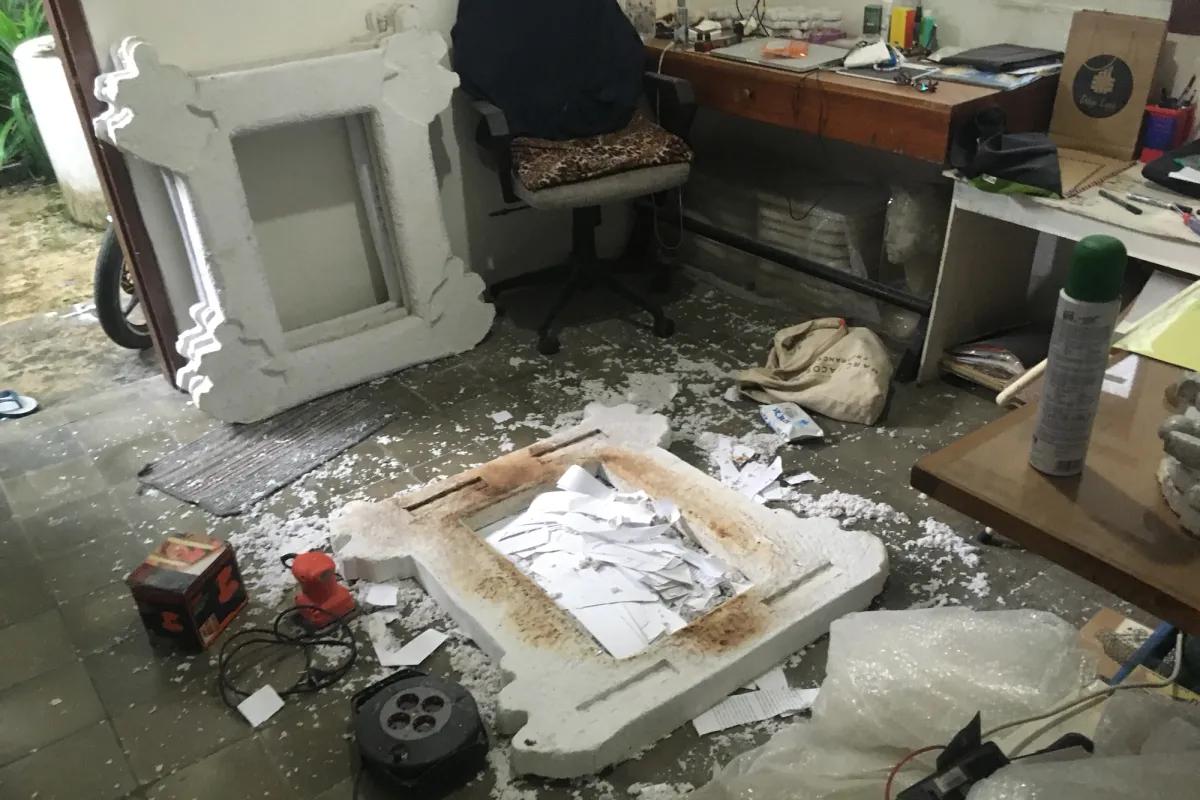 An artistic workshop including a creative piece, various art tools, and a solitary chair.