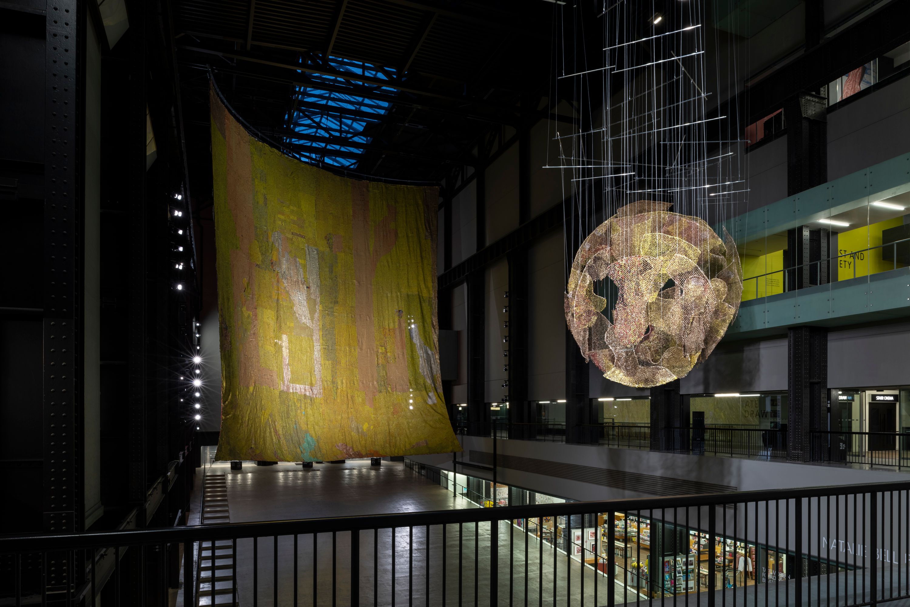 Two of El Anatsui’s hanging sculptures, The Red Moon and The World, at Tate Modern’s Turbine Hall.