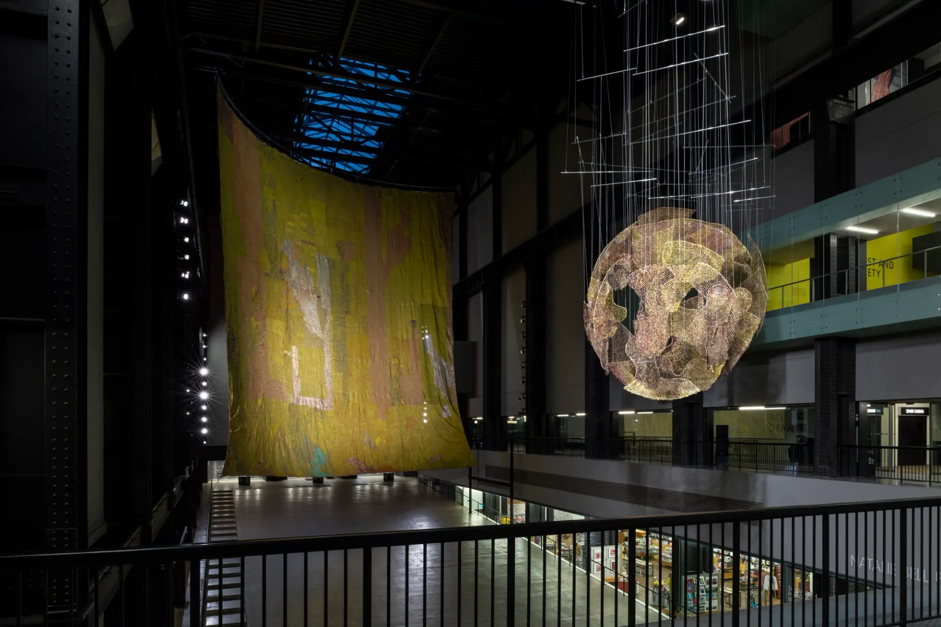 Two of El Anatsui’s hanging sculptures, The Red Moon and The World, at Tate Modern’s Turbine Hall.