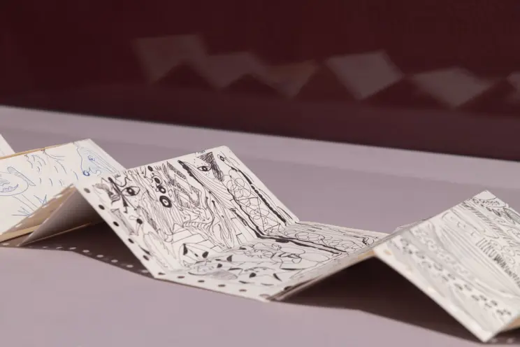 An intricate doodle art depicted on a folded, aged printer paper.