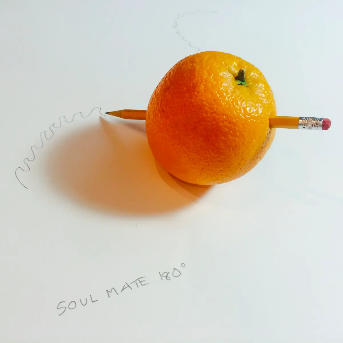 A pencil protruding from an orange, sketching squiggly lines with "soul mate 180°" inscribed nearby.