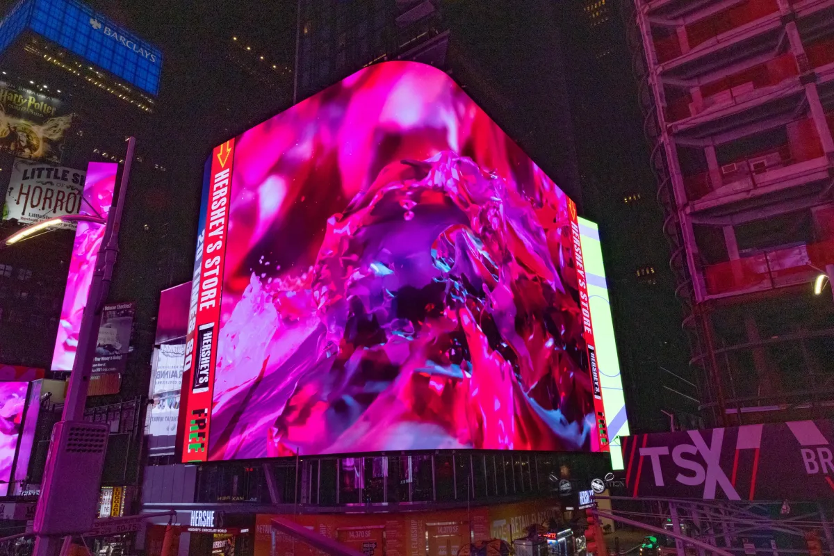 A corner building billboard in Times Square showcases a video of abstract art by Nancy Baker Cahill, 2022.