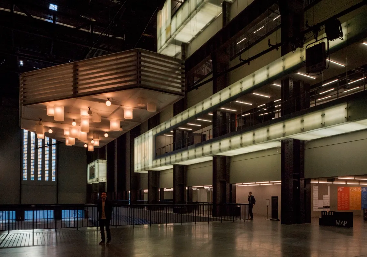 A spacious, well-lit hall inside of Tate Modern, featuring a clean minimalist aesthetic.