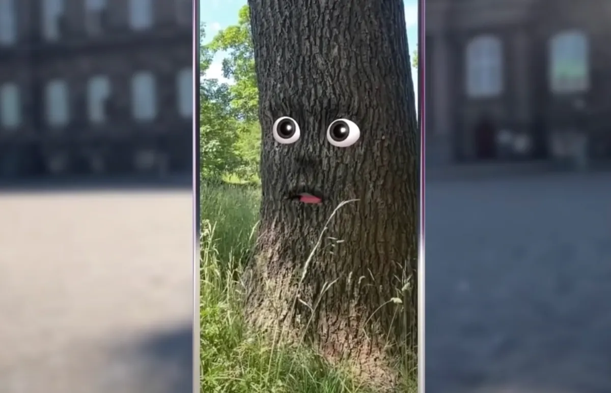 An illustrated tree with eyes and a mouth expressing amusement is superimposed onto a blurry image of weathered architecture. The tree is positioned centrally, as the focus of the image.