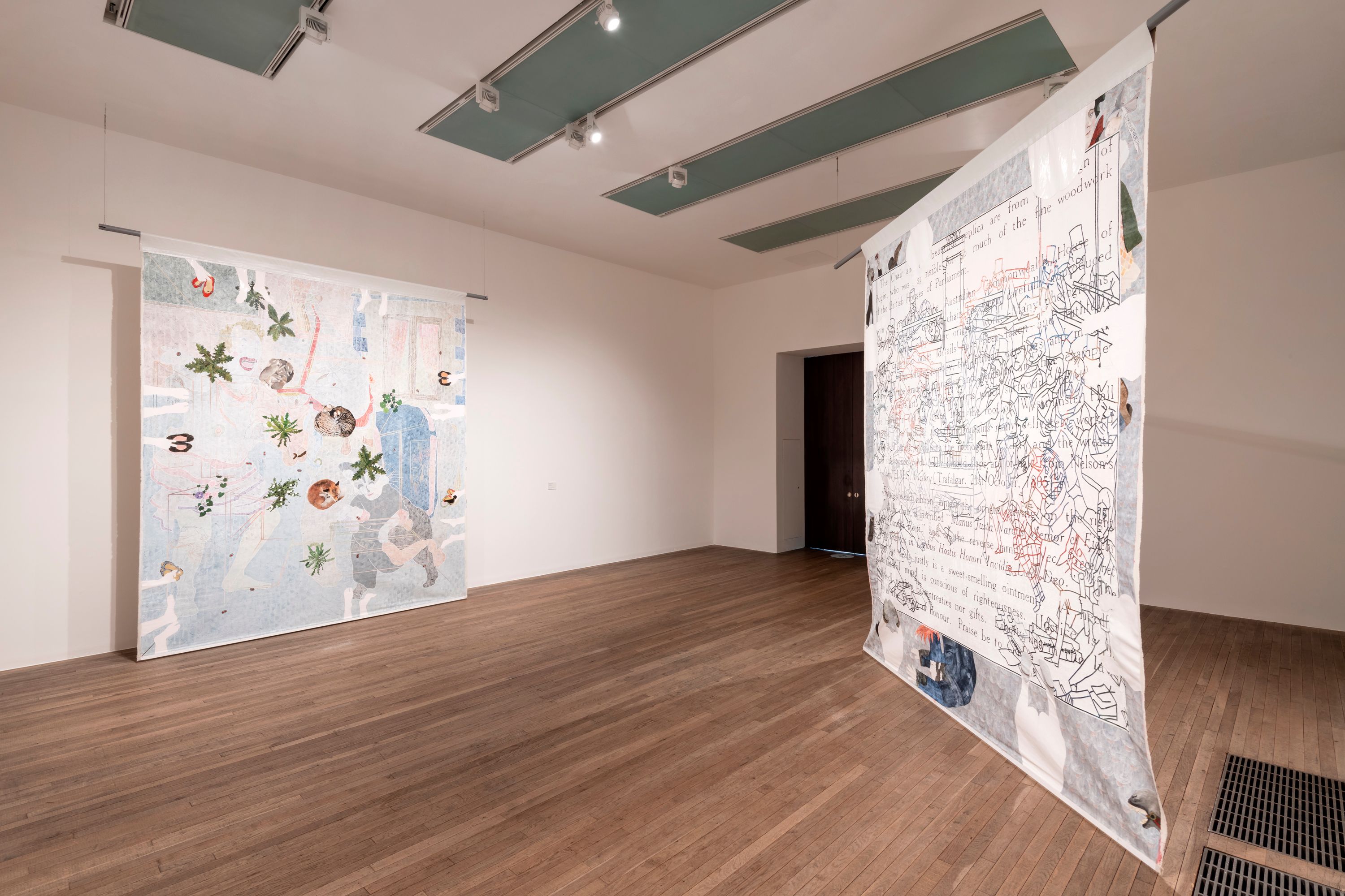 An art gallery with polished wooden floors, showcasing a collection of tapestry artwork hung on the white walls.