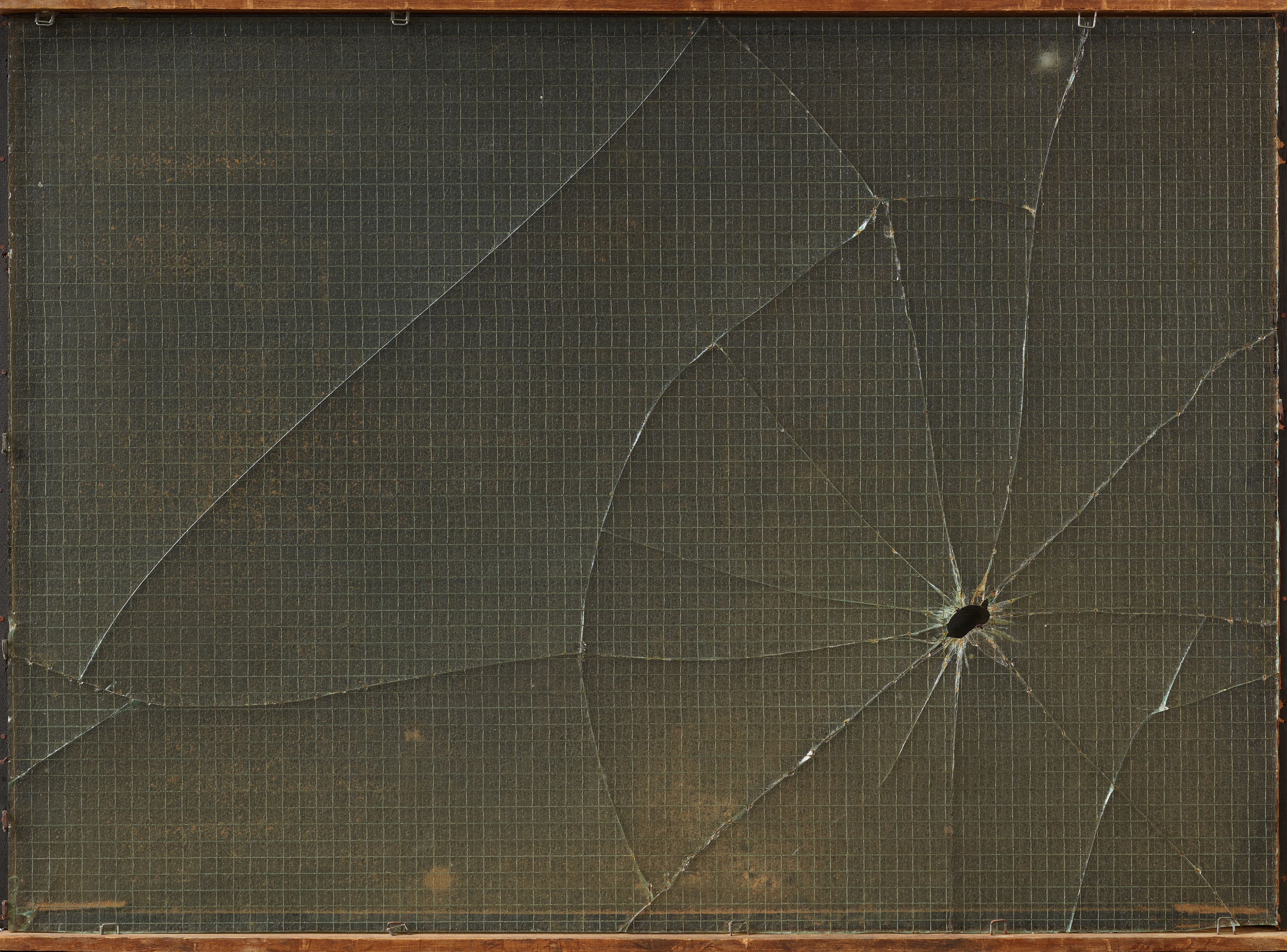 A bullet hole puncturing a clear glass window.