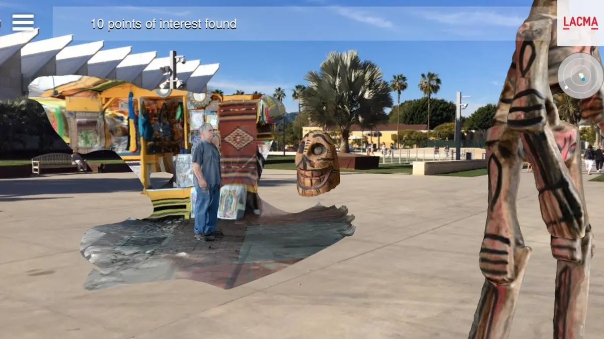 A screenshot from a mobile app shows a man standing in an augmented reality environment, with various art pieces surrounding him. The user interface displays a message indicating "10 points of interest found".