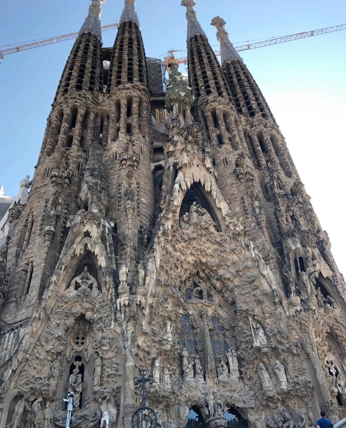 A large gothic-style cathedral with spires reaching into the sky amidst a city backdrop.
