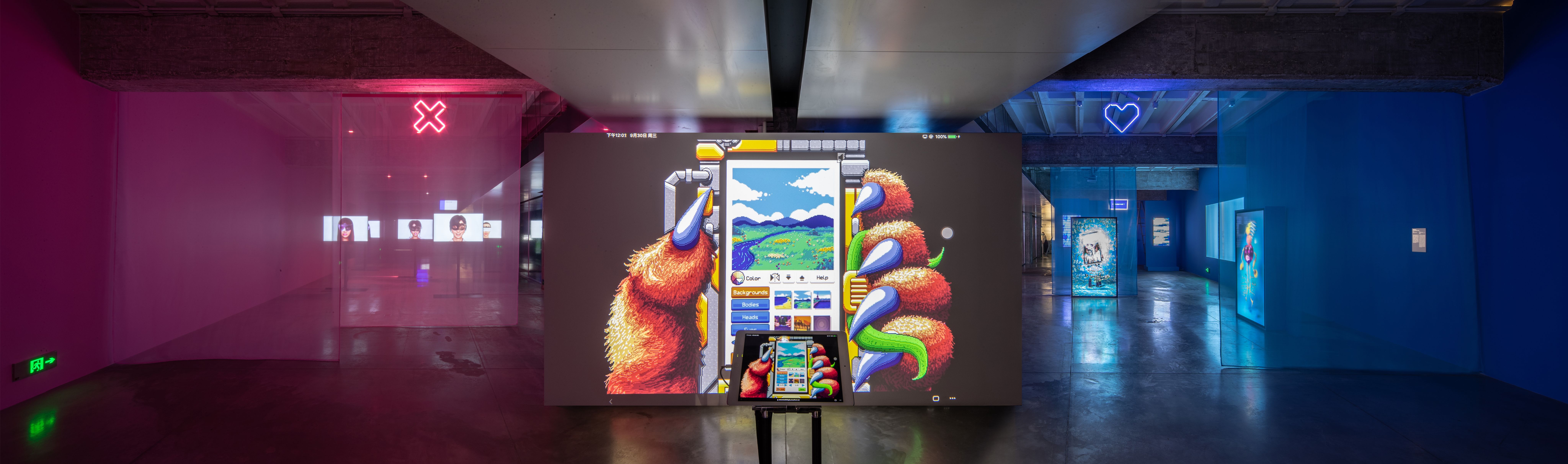 Art exhibit with a large interactive digital artwork and neon signs.