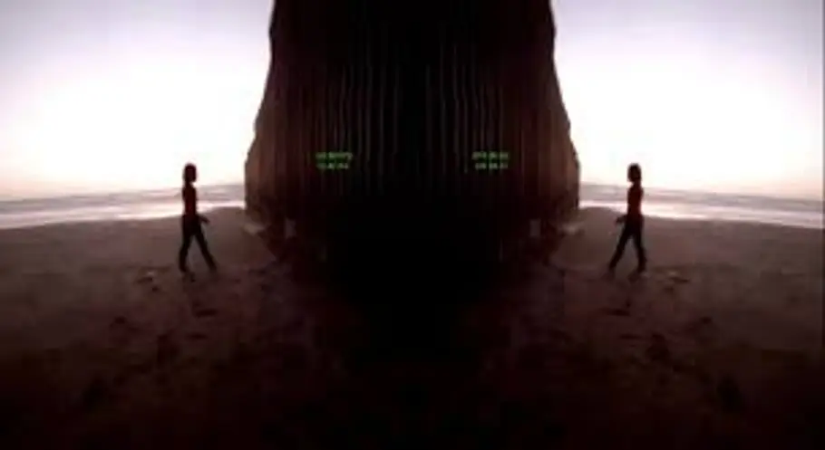 Two individuals standing outdoors with a distance between them, located on either side of a rugged, natural rock formation...