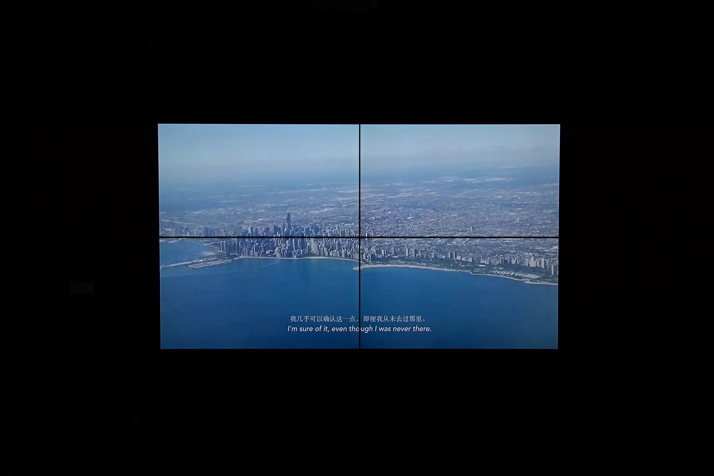 Two-part video screen showing a cityscape with subtitles.