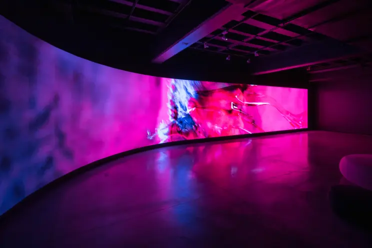 Curved wall displaying a large, vibrant digital art installation.