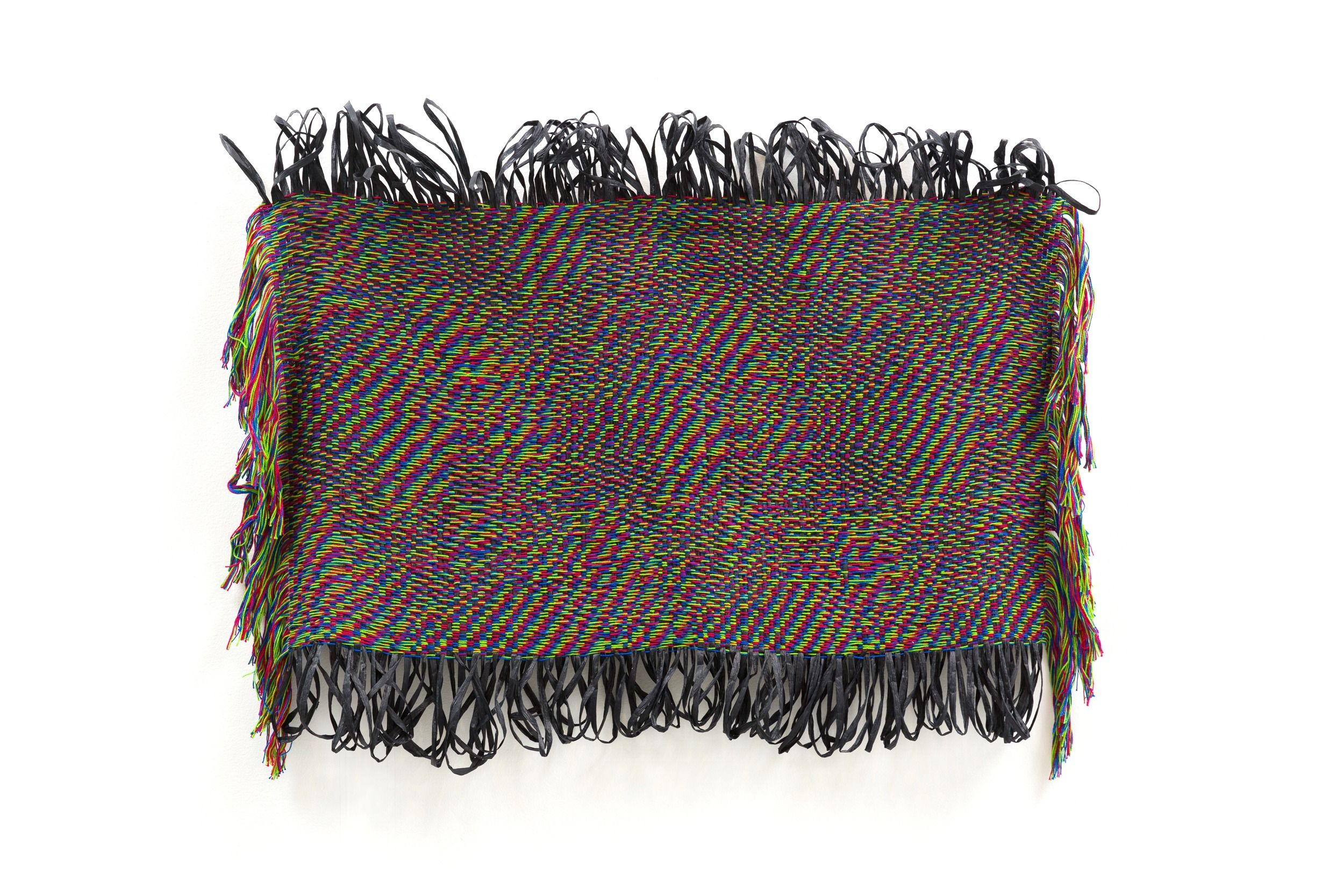 A woven textile artwork with vibrant, glitch-like RGB patterns and black fringe along the edges.
