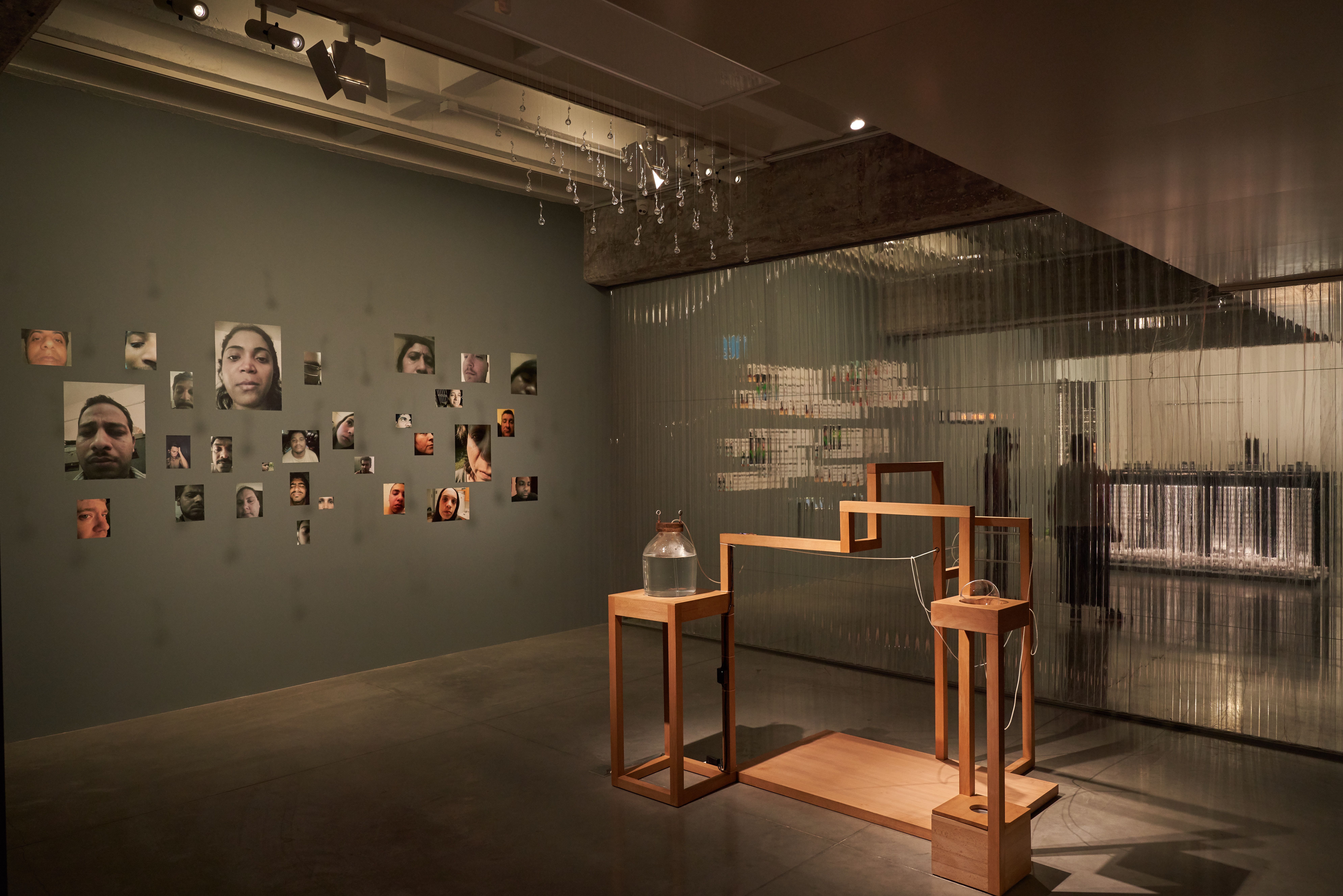 Art exhibit with portraits on the wall and wooden structures.