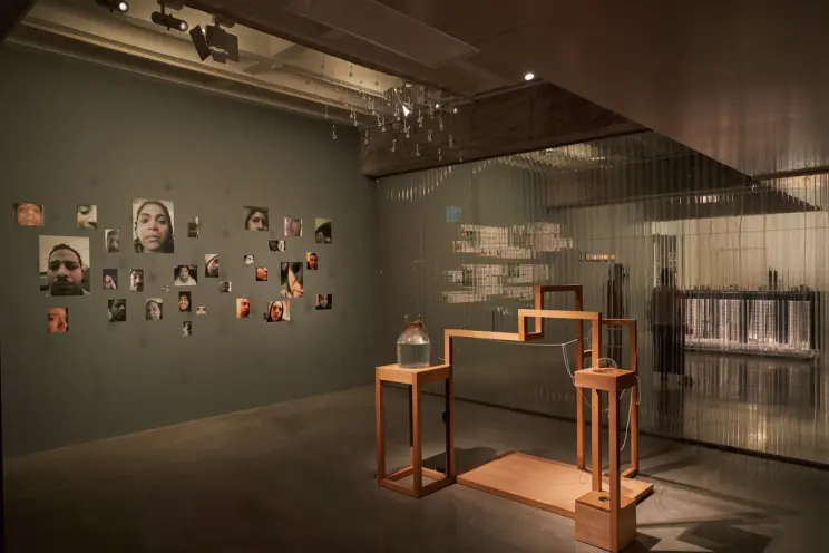 Art exhibit with portraits on the wall and wooden structures.