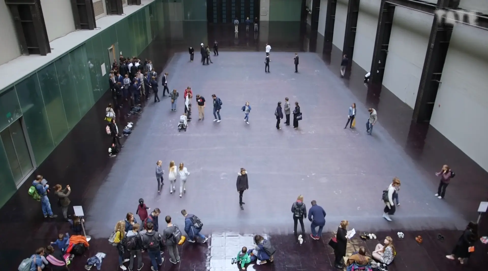 Overhead view of an open indoor space with numerous people milling about.