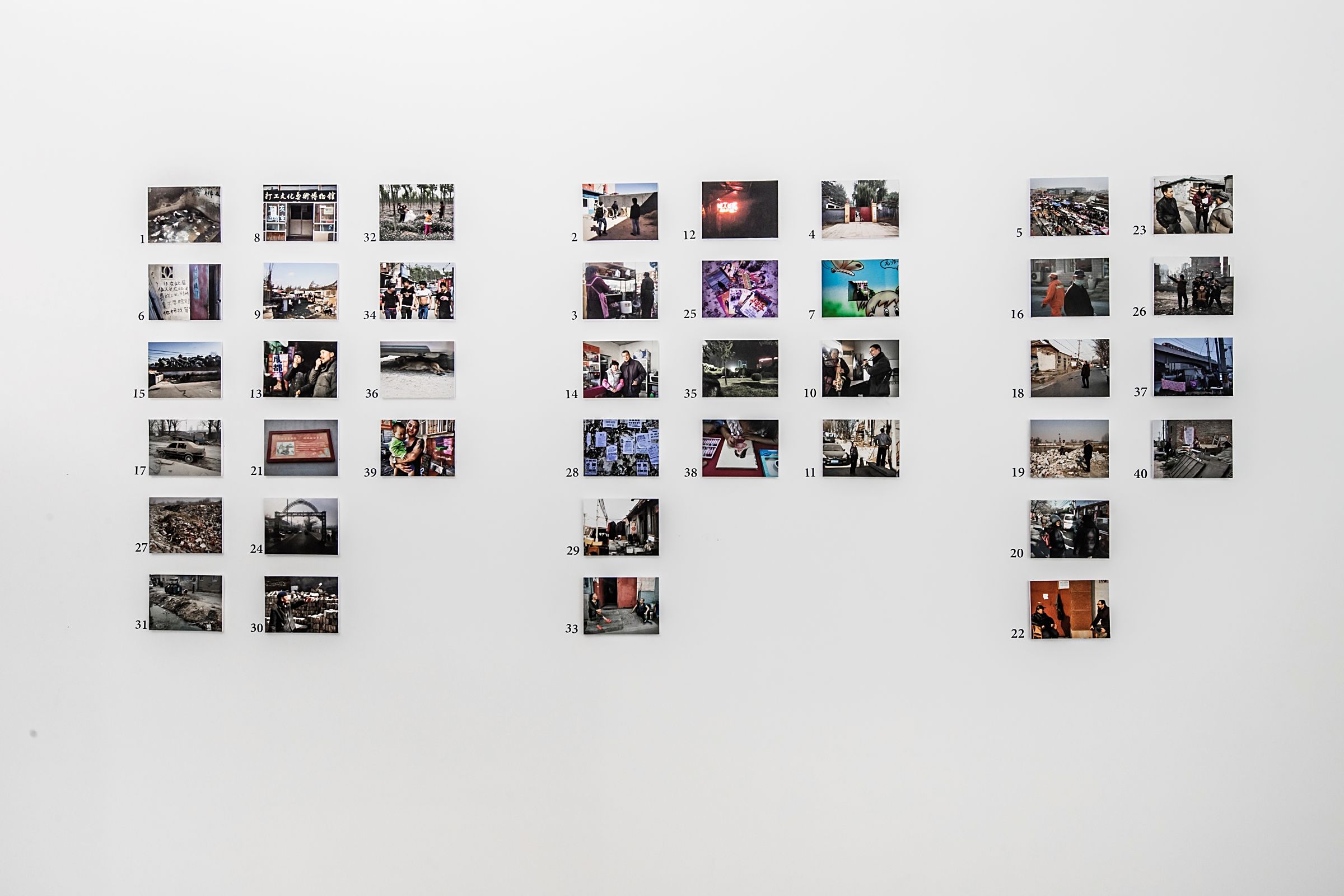 Wall with arrayed photos of various scenes.