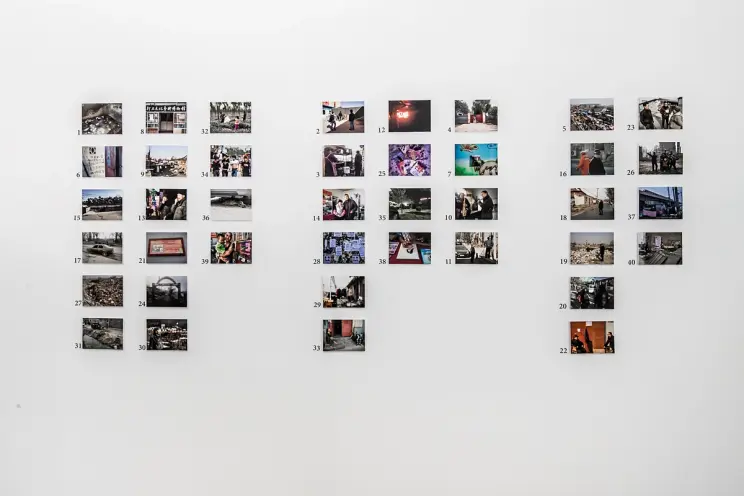 Wall with arrayed photos of various scenes.