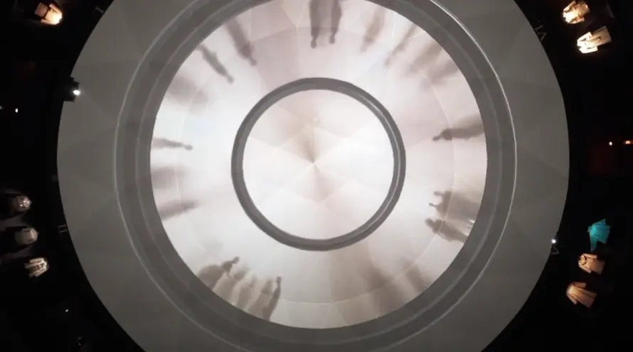 A digital art installation resembling a chandelier, with projections creating a dynamic, kaleidoscopic display.