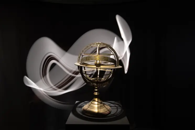 A celestial globe with dynamic lighting effects, displayed in a dark room.