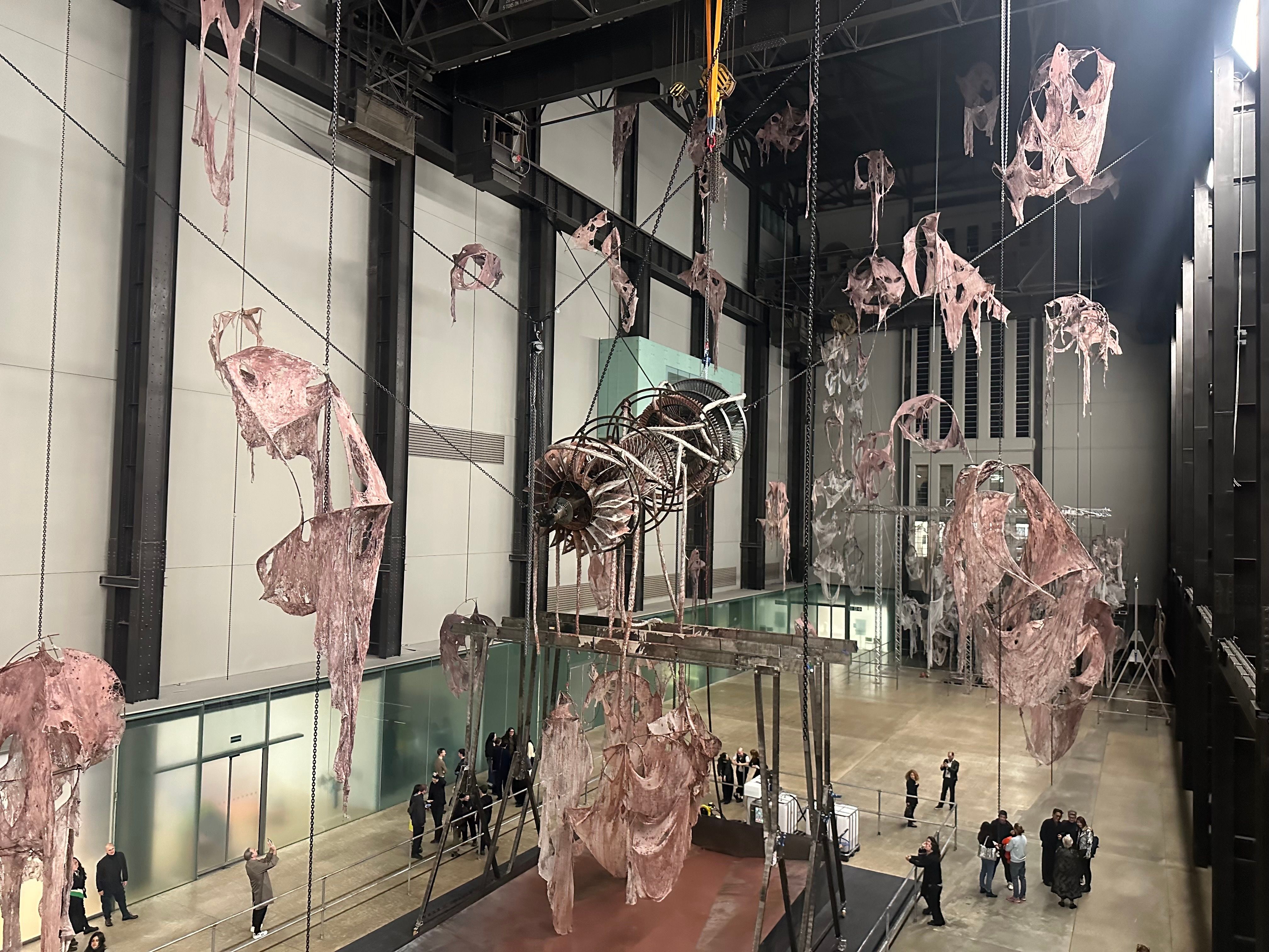 A close-up view of the hanging fabric-like sculptures, capturing intricate details of the material.