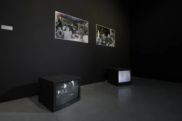 Dark room with photos on wall and TVs on floor.