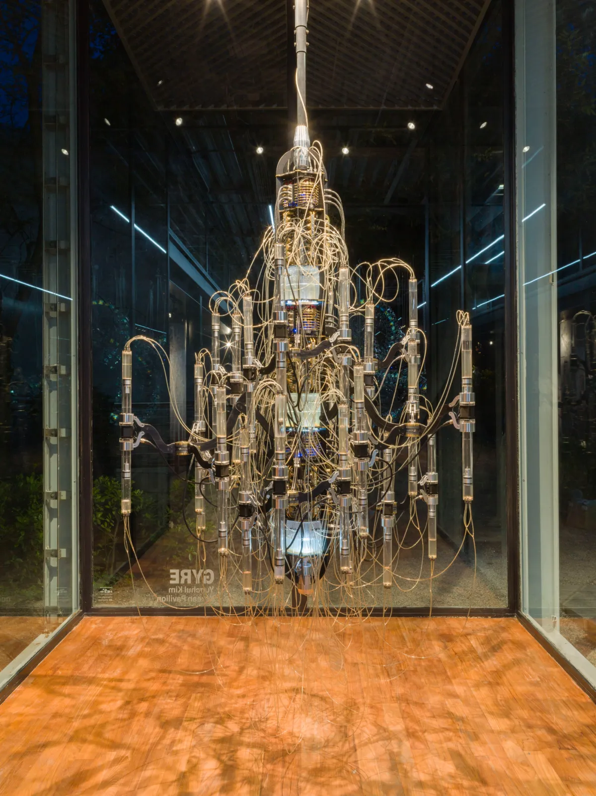 Artistic installation resembling a chandelier with intricate design, hanging at the Korean Pavilion in 2018, produced by Yunchul Kim.