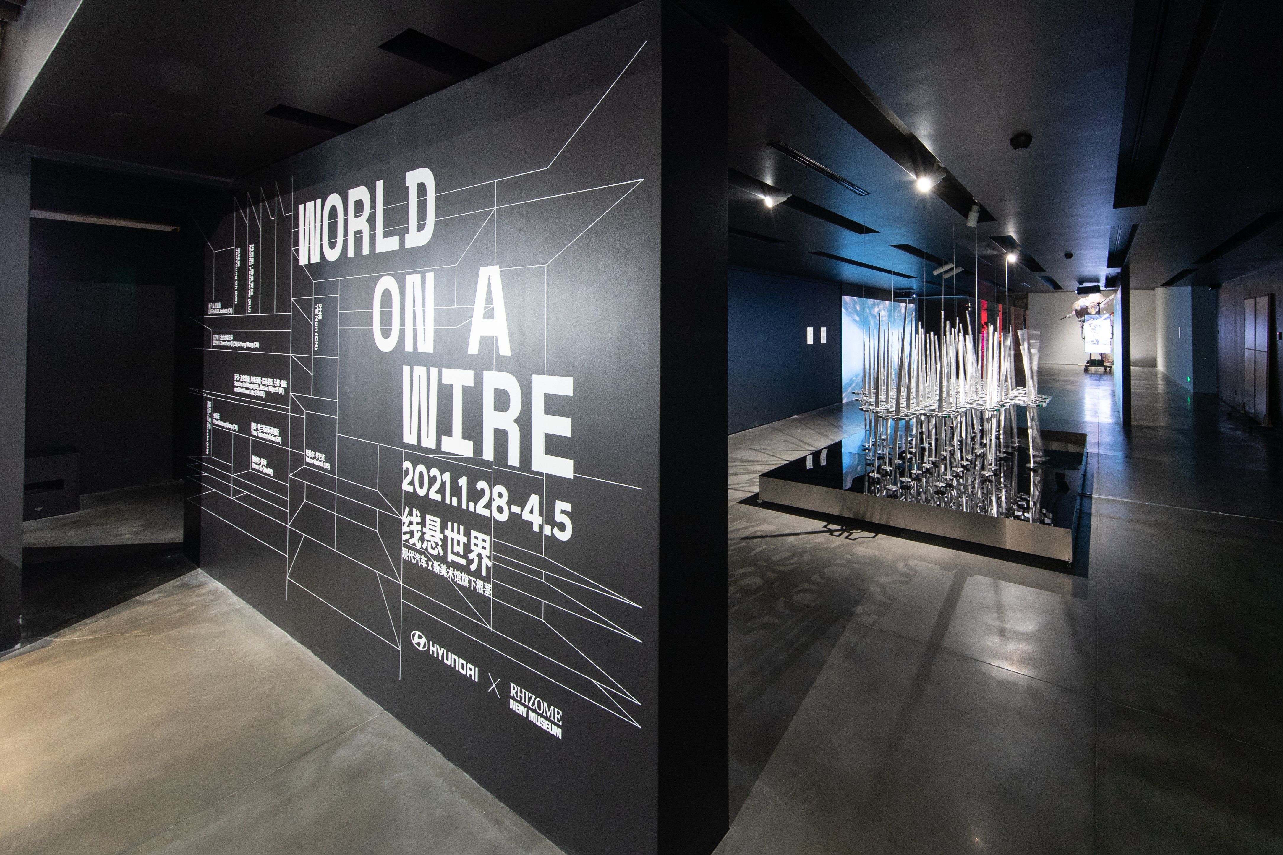 Exhibition entrance showcasing a large poster with the text "World on a Wire" and a glimpse of the installation inside.
