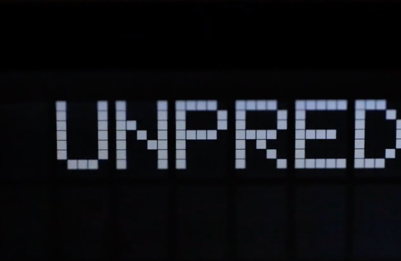 A black background featuring the word "Unpred", constructed from an array of small white squares, showcasing a typographic...