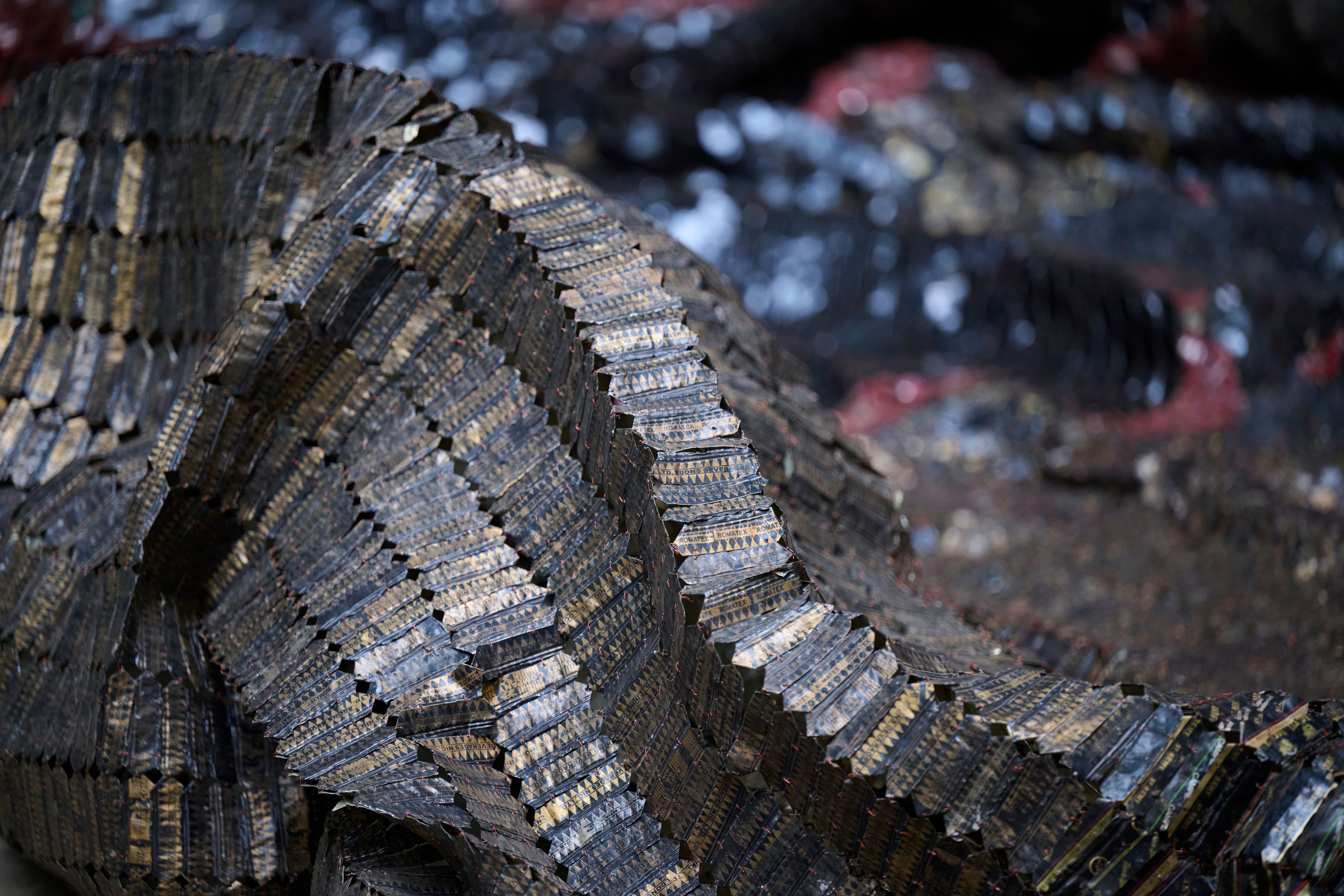 A close up of El Anatsui’s artwork, The Wall, which features sheets of black metal.